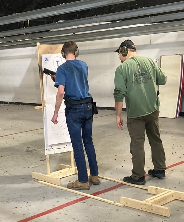A picture of Aaron at an indoor shooting range.